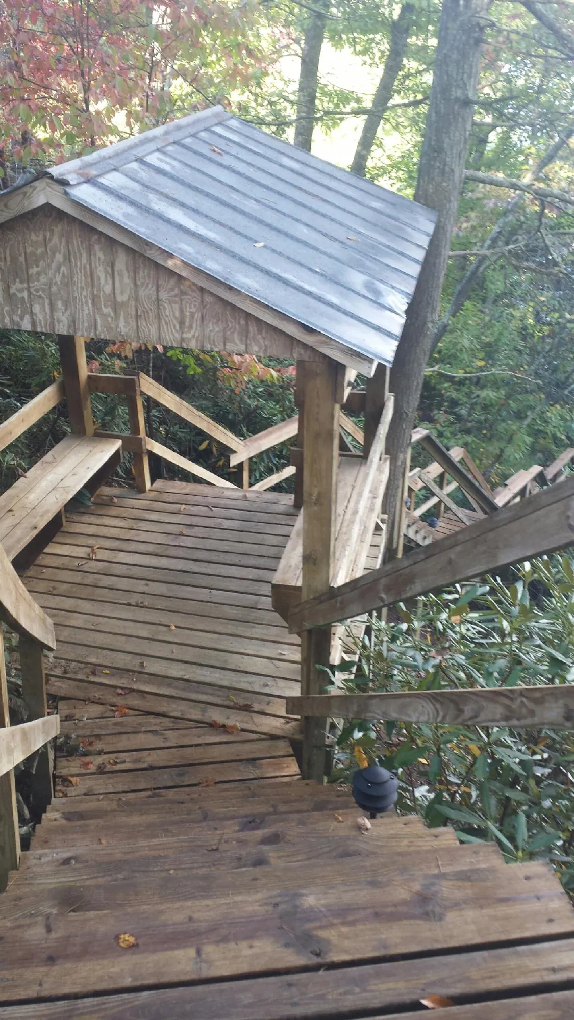 Metal roofed shelter over wooden steps on a wooded walkway — Skylight Repair & Installation work by our crew in Pleasant Lake