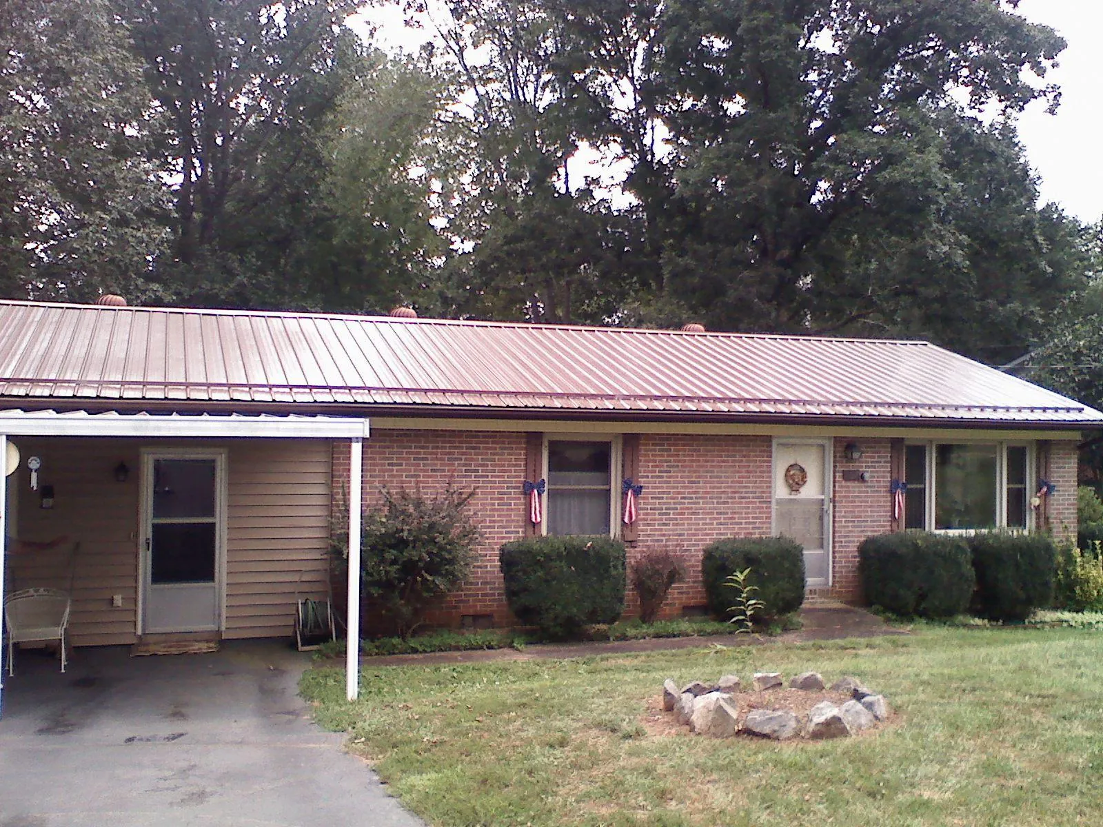 Bronze metal roof and carport on a brick ranch home — Roof Repair work by our crew in Pleasant Lake